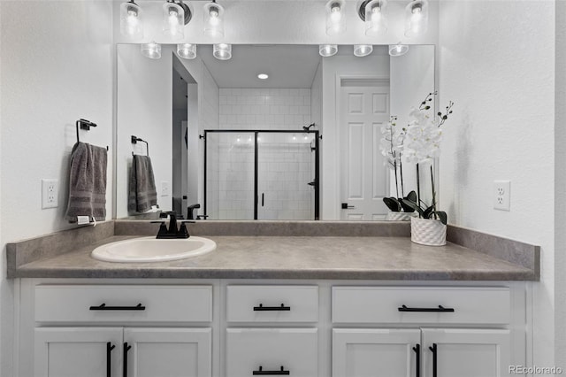 bathroom with vanity and a shower with door