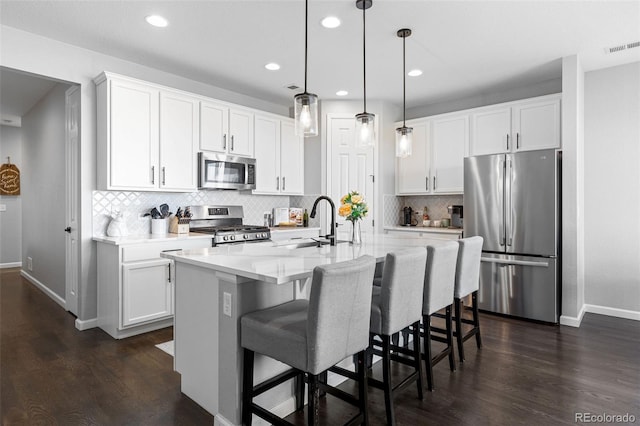 27491 E 10th Dr, Aurora, CO 80018 - kitchen featuring appliances with stainless steel finishes, dark wood finished floors, light countertops, backsplash, and recessed lighting
