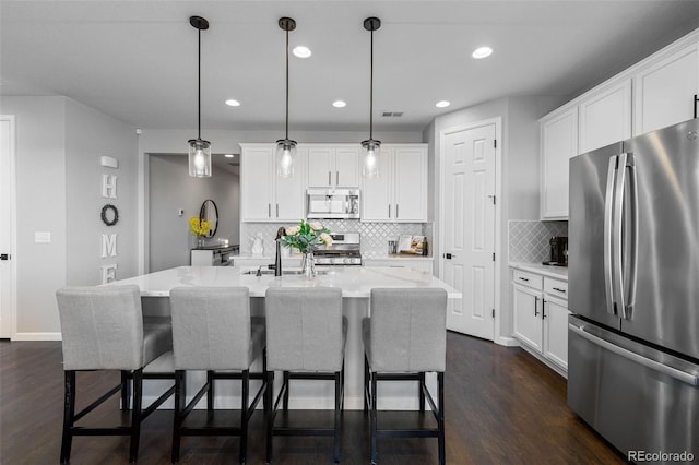 27491 E 10th Dr, Aurora, CO 80018 - kitchen featuring stainless steel appliances, dark wood-type flooring, a kitchen breakfast bar, white cabinets, and recessed lighting