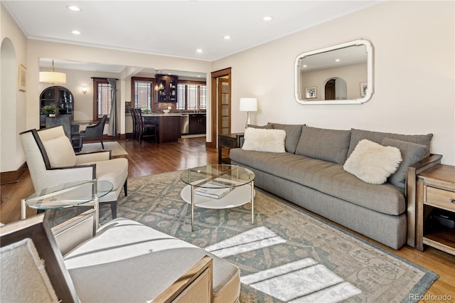 living area with crown molding, wood finished floors, and recessed lighting
