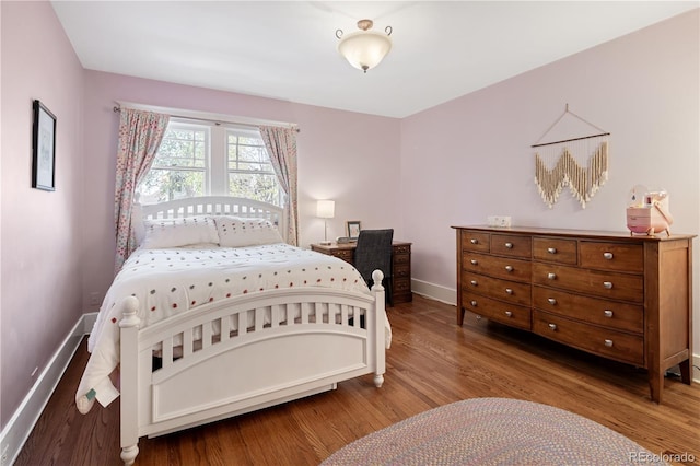 bedroom with baseboards and wood finished floors