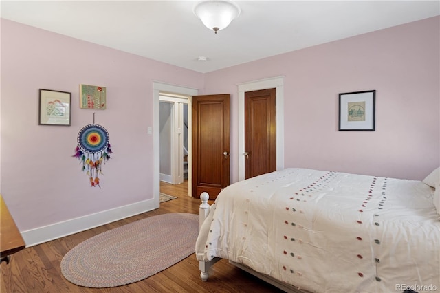 bedroom featuring wood finished floors and baseboards