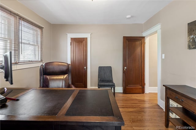 office space with baseboards and light wood-style floors