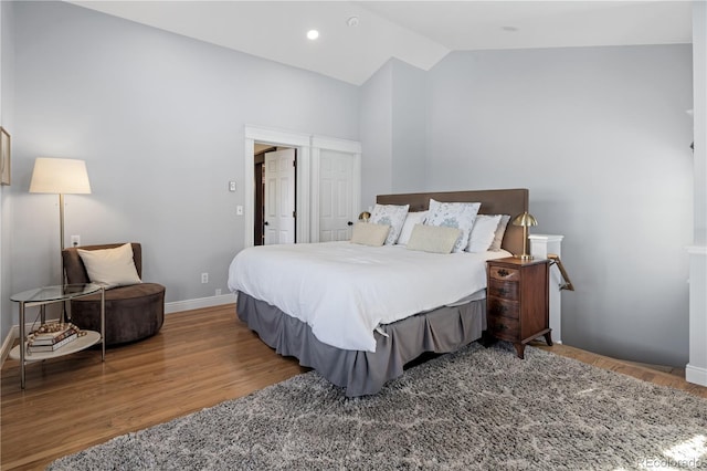 bedroom with lofted ceiling, baseboards, recessed lighting, and wood finished floors