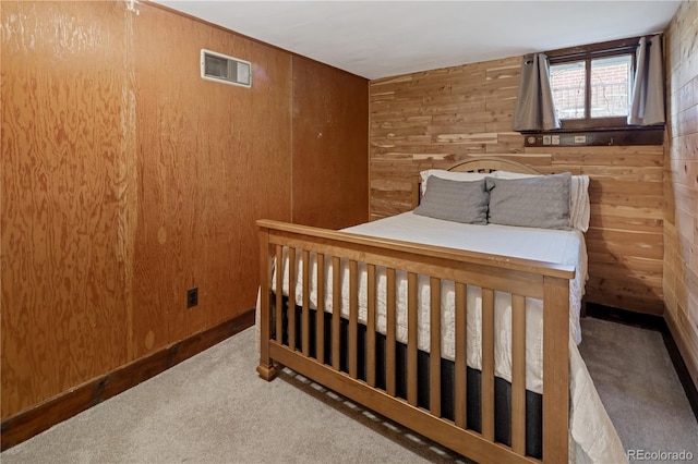 carpeted bedroom featuring wooden walls and visible vents