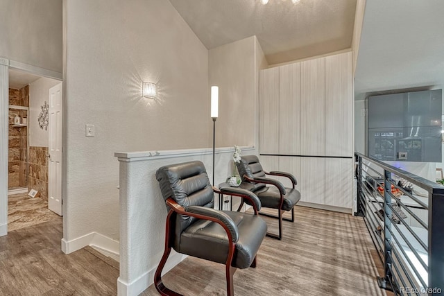 5173 S Emporia Way, Greenwood Village, CO 80111 - living area featuring wood finished floors, a textured wall, and vaulted ceiling