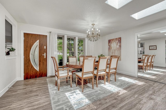 5173 S Emporia Way, Greenwood Village, CO 80111 - dining room featuring wood finished floors, a chandelier, a skylight, and a textured ceiling