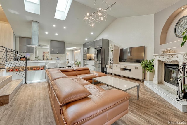 5173 S Emporia Way, Greenwood Village, CO 80111 - living area featuring light wood-style floors, a premium fireplace, a skylight, stairway, and high vaulted ceiling