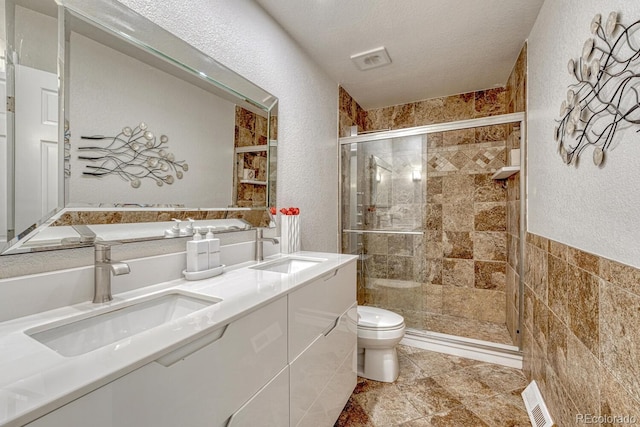 5173 S Emporia Way, Greenwood Village, CO 80111 - bathroom featuring a textured wall, a stall shower, double vanity, and a textured ceiling