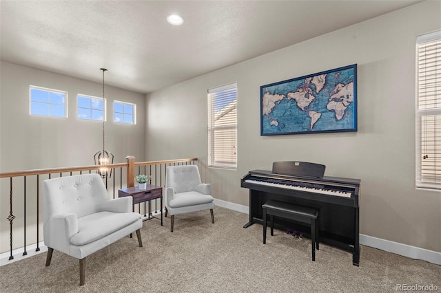 living area with carpet, a textured ceiling, and an inviting chandelier