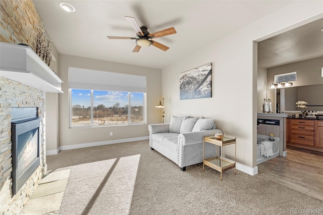 living room with light carpet, a fireplace, and ceiling fan