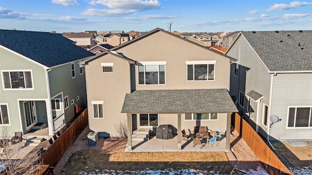 back of property with central AC and a patio