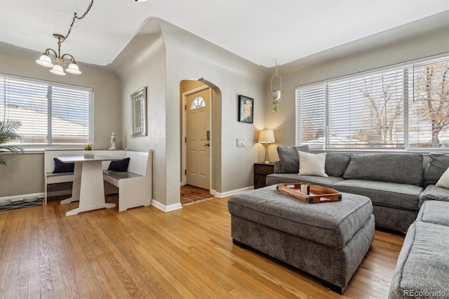 living room featuring light wood-type flooring and a notable chandelier