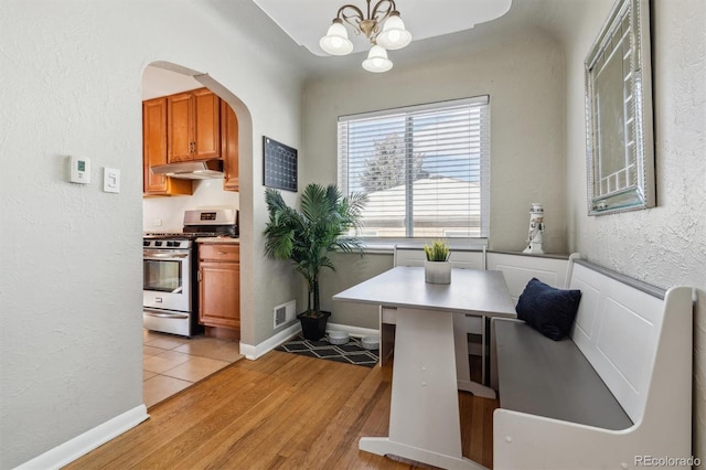 dining area with an inviting chandelier and light hardwood / wood-style flooring