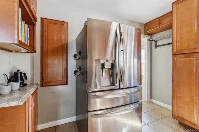 kitchen with light tile patterned floors and stainless steel fridge