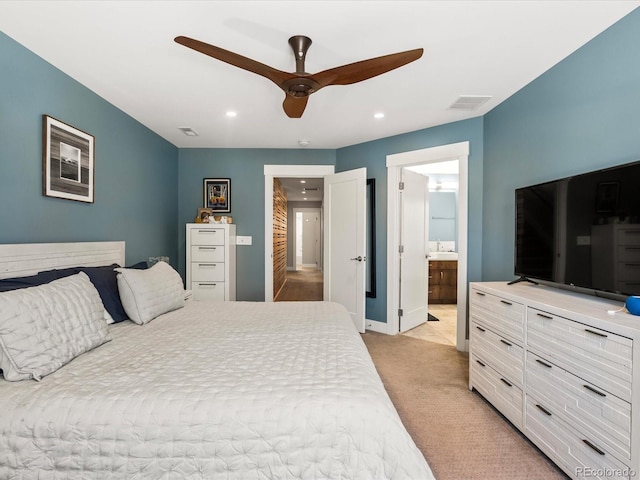 carpeted bedroom featuring sink, ceiling fan, and ensuite bath