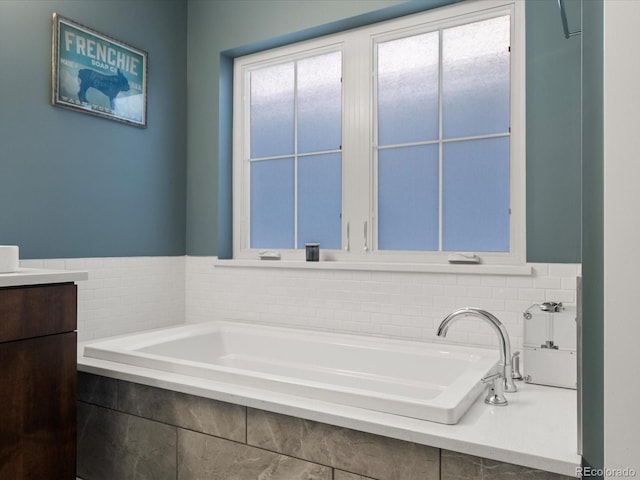 bathroom with a relaxing tiled tub and vanity