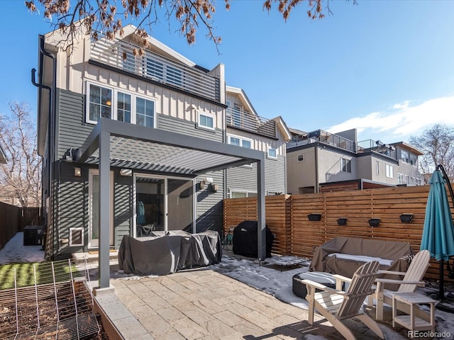 rear view of property featuring a pergola and a patio area