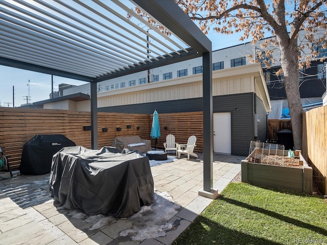 view of patio with area for grilling and a pergola