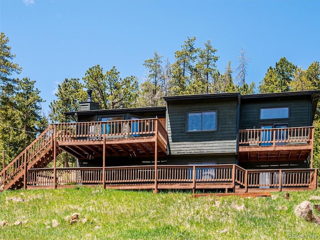 34075 Grouse Ln, Evergreen, CO 80439 - back of property with stairway, a wooden deck, a lawn, and a chimney