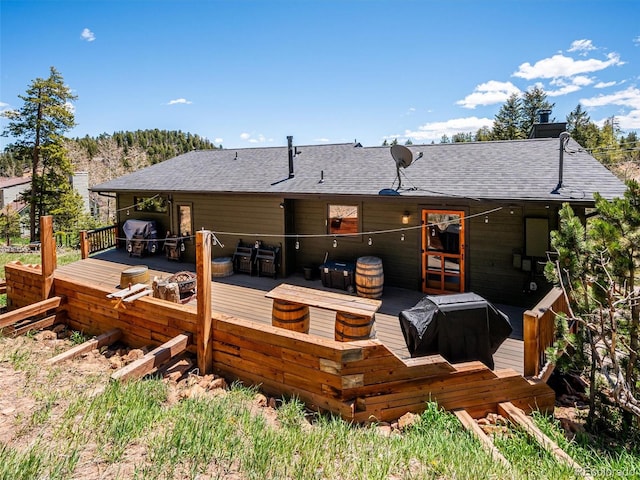 34075 Grouse Ln, Evergreen, CO 80439 - back of property with a shingled roof, a deck, and a chimney
