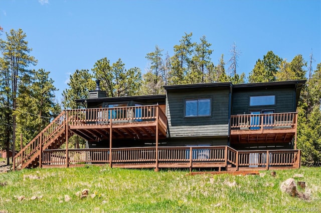 34075 Grouse Ln, Evergreen, CO 80439 - back of property featuring a deck, stairs, and a lawn