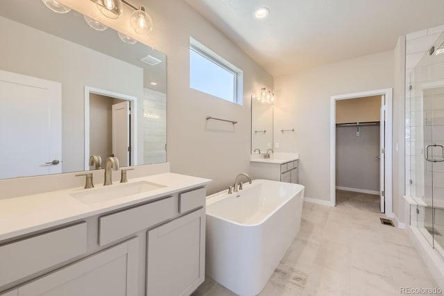 bathroom featuring visible vents, a spacious closet, a stall shower, a sink, and a freestanding tub