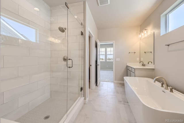 full bath with visible vents, baseboards, a soaking tub, vanity, and a shower stall