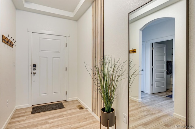 entrance foyer featuring light wood-style floors, visible vents, and baseboards