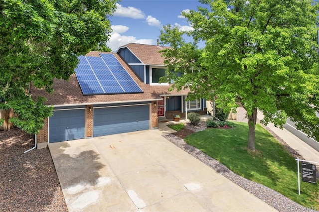 13701 Yank Way, Arvada, CO 80004 - view of front of property with an attached garage, driveway, brick siding, a shingled roof, and solar panels