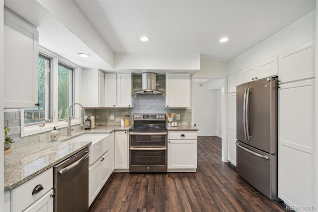 13701 Yank Way, Arvada, CO 80004 - kitchen with stainless steel appliances, wall chimney exhaust hood, white cabinetry, backsplash, and recessed lighting