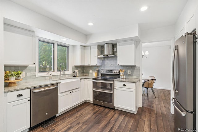 13701 Yank Way, Arvada, CO 80004 - kitchen with stainless steel appliances, wall chimney range hood, white cabinetry, dark wood finished floors, and recessed lighting