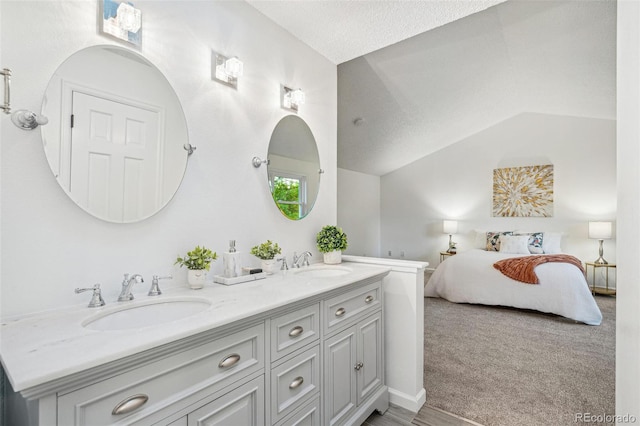 13701 Yank Way, Arvada, CO 80004 - bathroom with ensuite bathroom, double vanity, a textured ceiling, and lofted ceiling