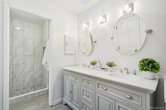 13701 Yank Way, Arvada, CO 80004 - bathroom featuring double vanity, tiled shower, and wood finished floors