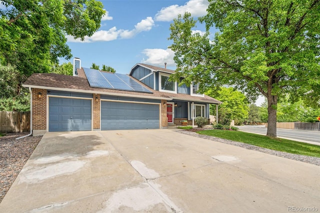 13701 Yank Way, Arvada, CO 80004 - traditional-style home featuring concrete driveway, solar panels, brick siding, and an attached garage