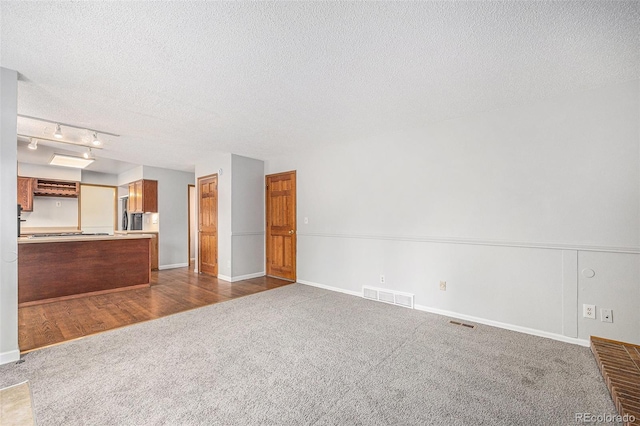 16835 E Harvard Pl, Aurora, CO 80013 - unfurnished living room featuring dark carpet and a textured ceiling