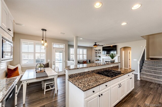4968 Montvale Dr, Highlands Ranch, CO 80130 - kitchen with stainless steel appliances, arched walkways, dark wood-type flooring, and a kitchen island