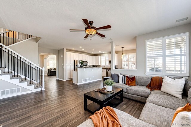 4968 Montvale Dr, Highlands Ranch, CO 80130 - living area featuring arched walkways, stairway, visible vents, and a ceiling fan