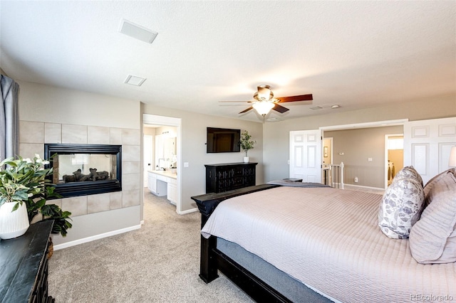 4968 Montvale Dr, Highlands Ranch, CO 80130 - bedroom featuring baseboards, ensuite bathroom, ceiling fan, a tile fireplace, and light colored carpet