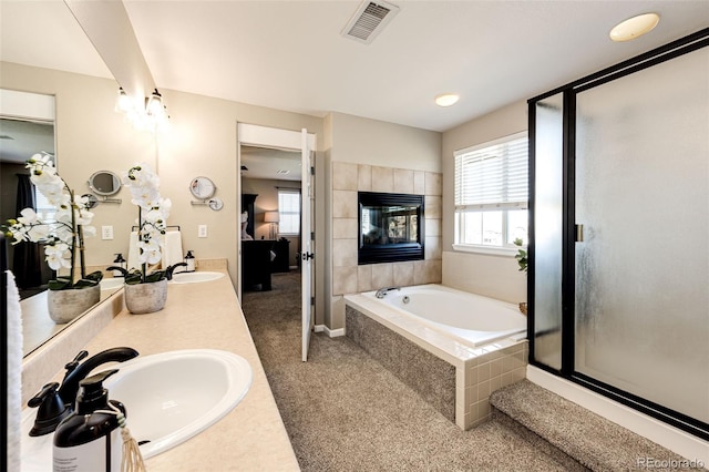 4968 Montvale Dr, Highlands Ranch, CO 80130 - full bath featuring a tiled fireplace, visible vents, plenty of natural light, and ensuite bath