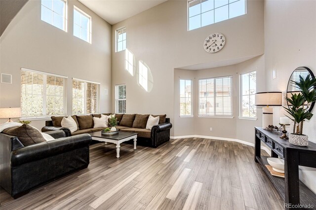 4968 Montvale Dr, Highlands Ranch, CO 80130 - living room with wood finished floors, visible vents, a towering ceiling, and baseboards