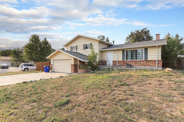 tri-level home with a garage and a front lawn