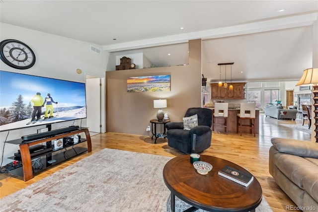 living room with light wood-style flooring and high vaulted ceiling