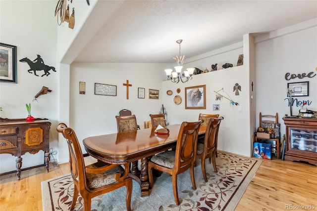 dining area with light wood finished floors and a chandelier
