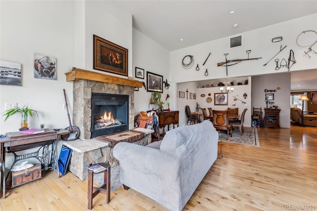 510 Park View Ln, Gypsum, CO 81637 - living area with wood finished floors, a stone fireplace, a chandelier, and a towering ceiling