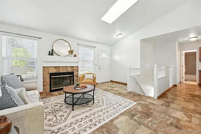 5193 S Flanders Ln, Centennial, CO 80015 - living area with stone tile floors, healthy amount of natural light, a fireplace, lofted ceiling, and a skylight