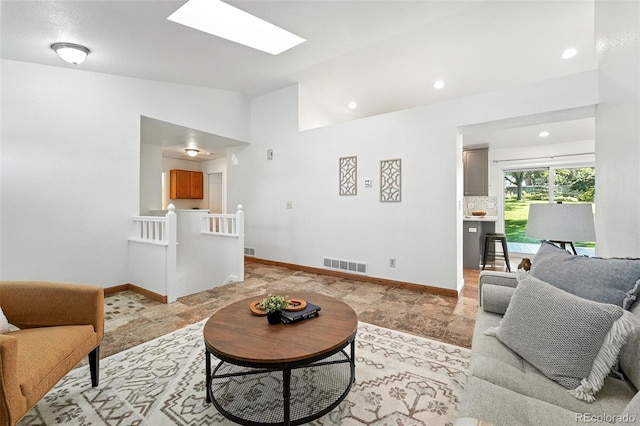 5193 S Flanders Ln, Centennial, CO 80015 - living area featuring lofted ceiling, stone tile floors, a skylight, and recessed lighting