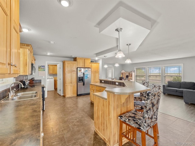 47855 E 88th Ave, Bennett, CO 80102 - kitchen featuring appliances with stainless steel finishes, washer / clothes dryer, open floor plan, a sink, and a breakfast bar area