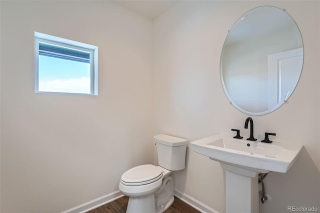 bathroom with hardwood / wood-style flooring and toilet