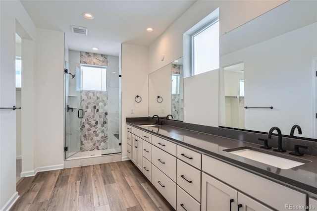 bathroom with walk in shower, vanity, and hardwood / wood-style floors